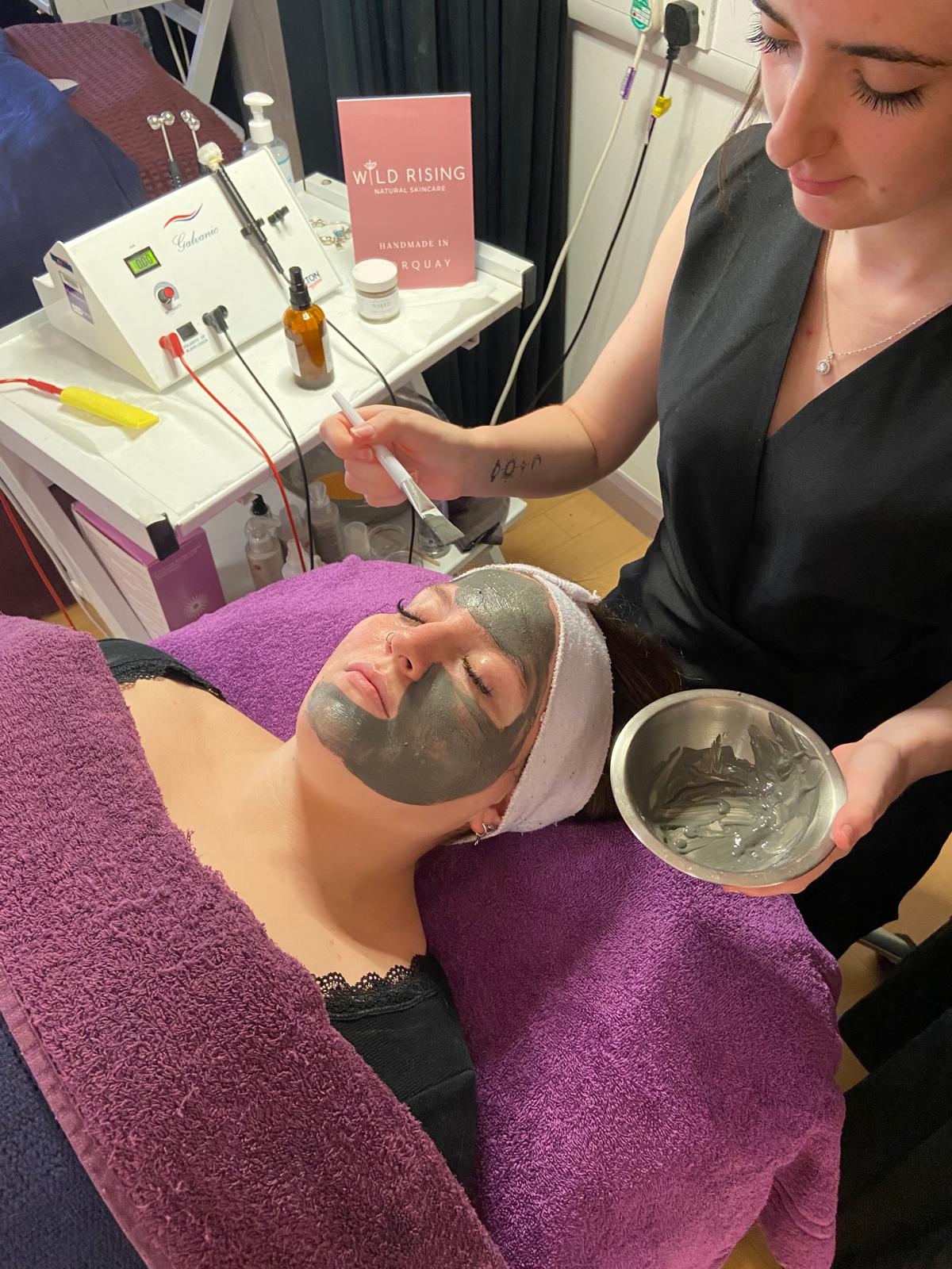 black face mask being applied to girl laying down