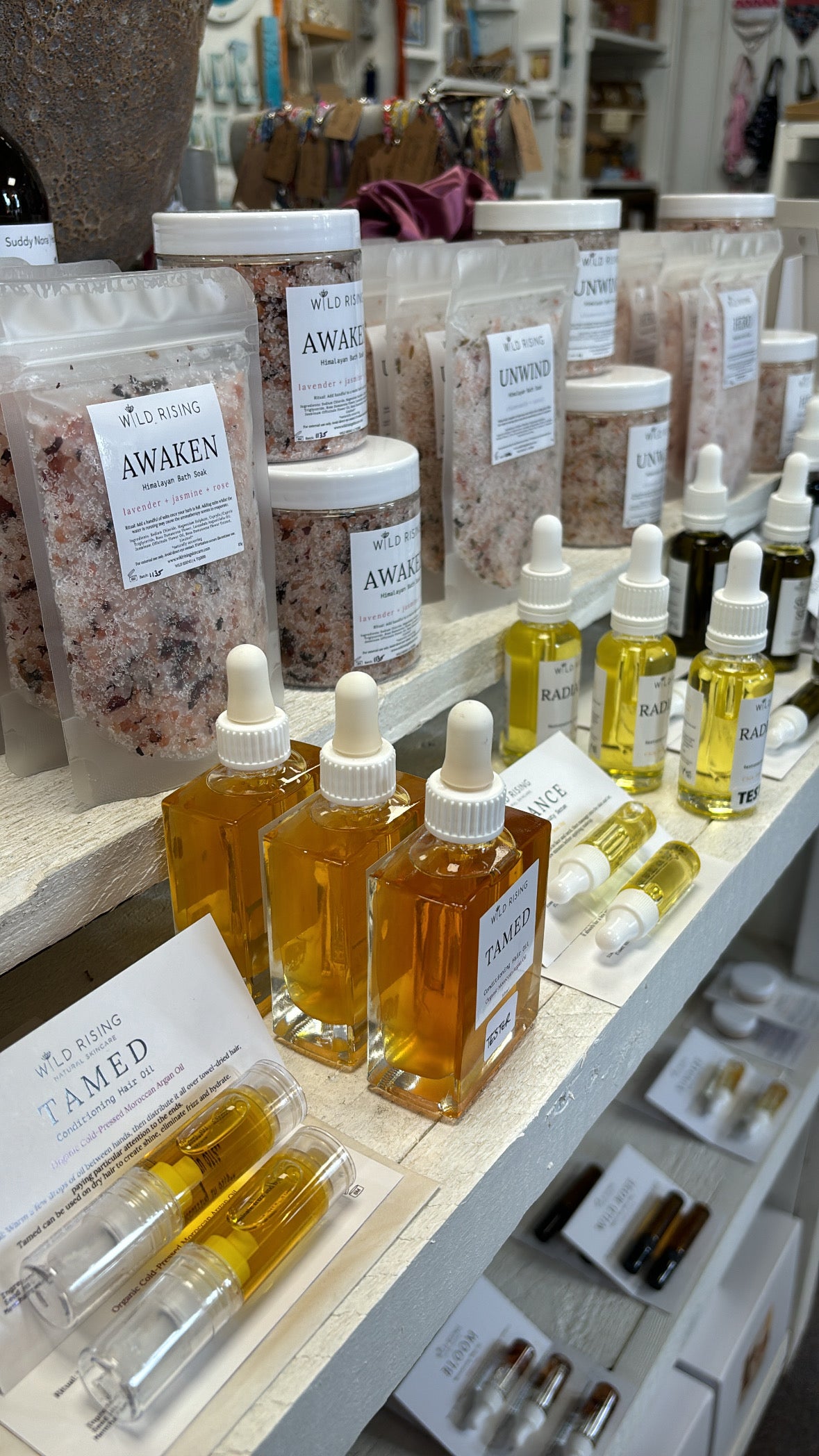 Assorted skincare products on a shelf with 'Awaken' labeled bottles.