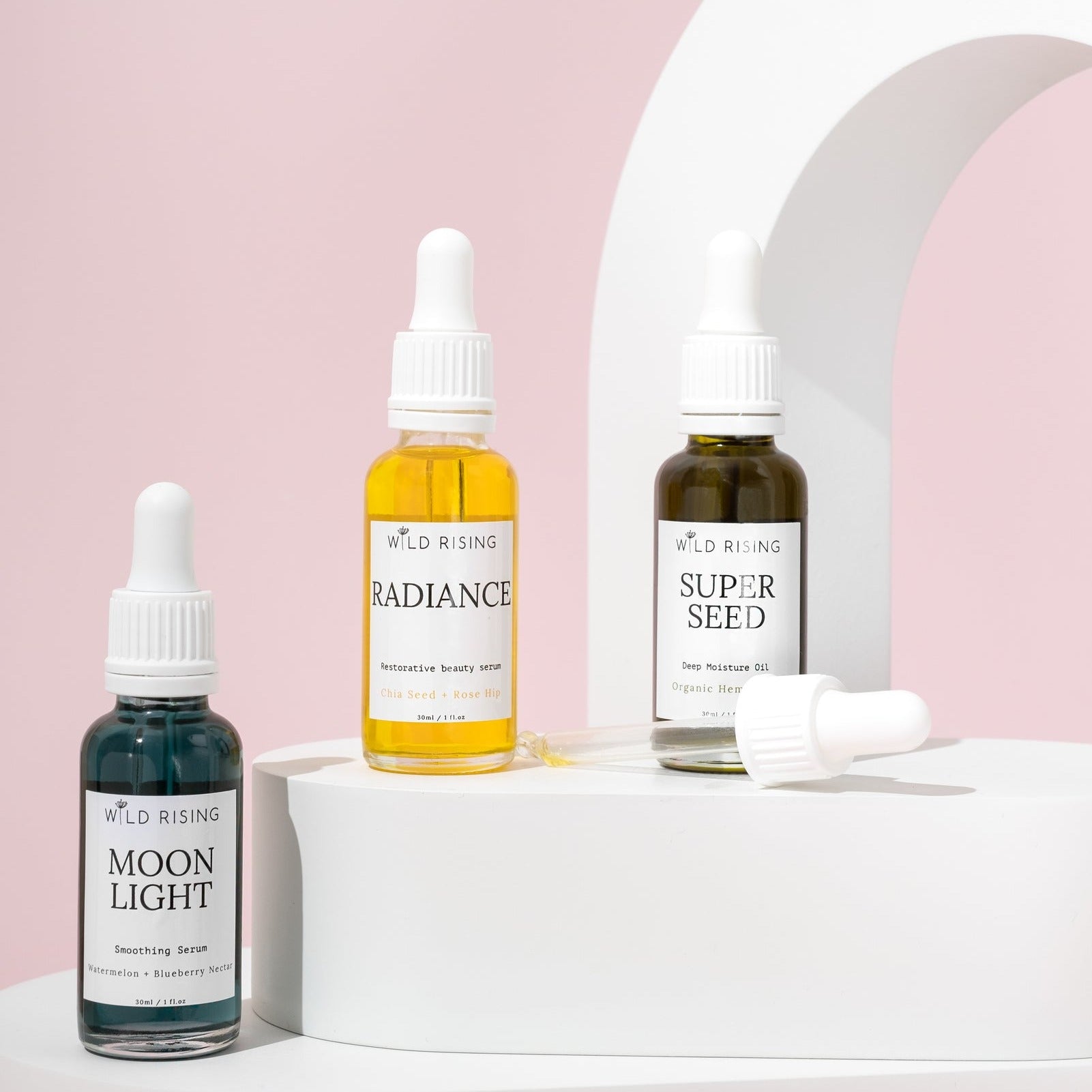 trio of wild rising natural face oils. Moonlight, Radiance and Super Seed stood on a white block