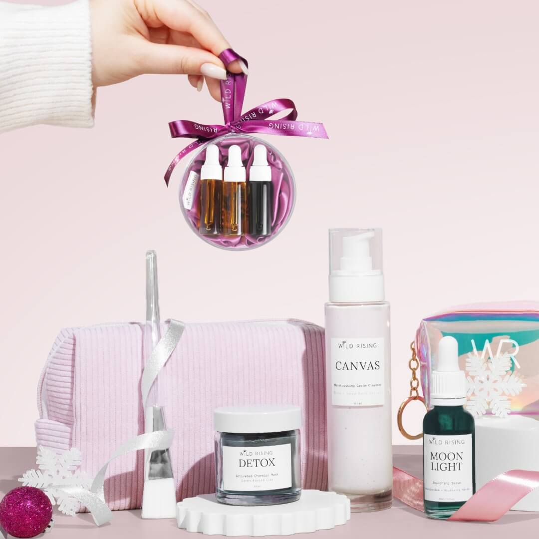 a christmas beauty bauble behind held over skincare products