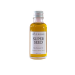 A small glass bottle of Wild Rising Super Seed Deep Moisture Oil filled with golden-yellow oil, featuring a white label and a silver metal cap, set against a plain white background.