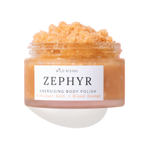 A clear jar of Wild Rising Zephyr Energising Body Polish filled with a peachy-orange granular scrub, shown on a white background with a soft shadow.