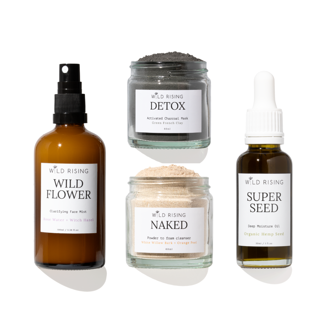 four glass skincare products on white background