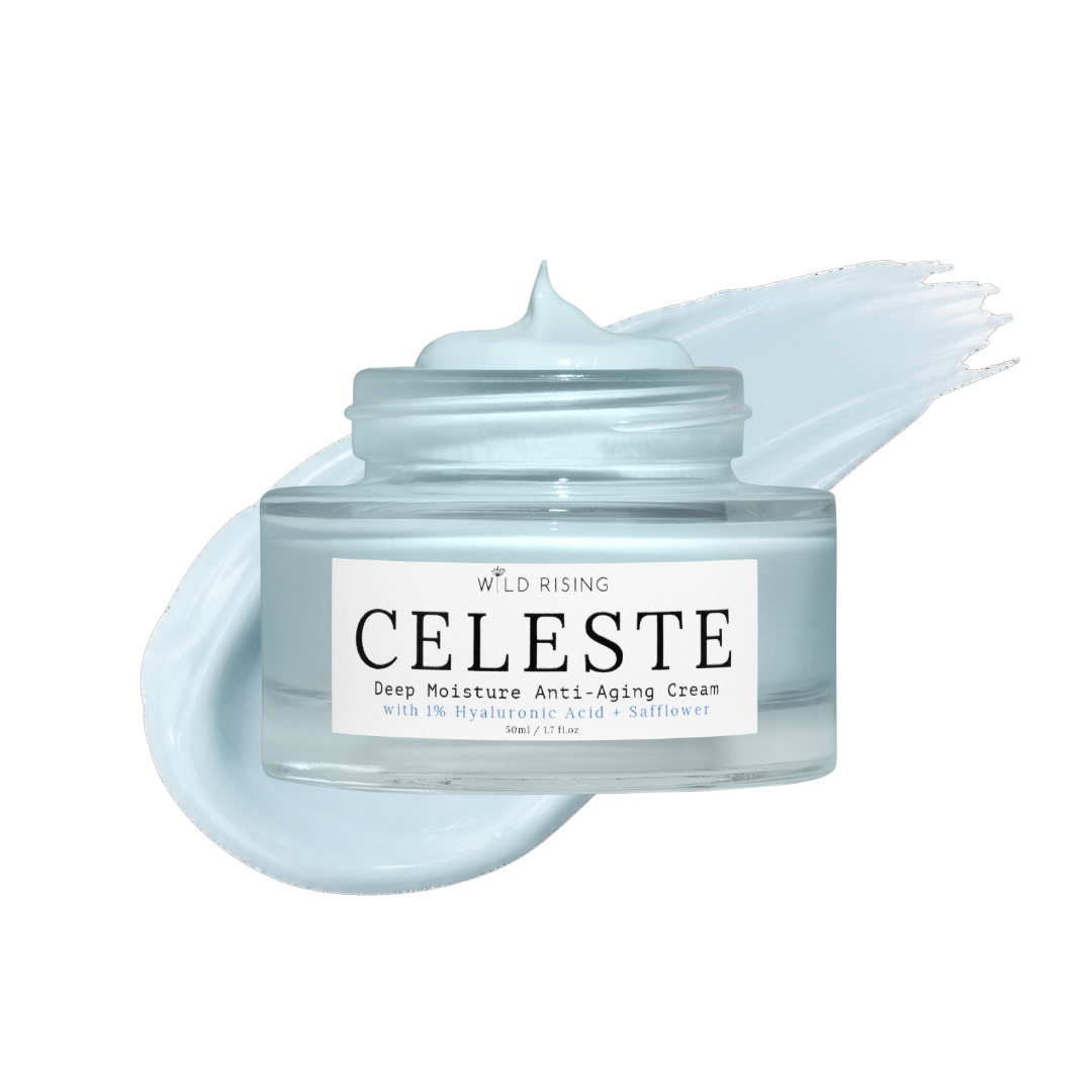 A clear cosmetic jar of Wild Rising Celeste Deep Moisture Anti-Aging Cream with a white label, shown with a pale icy blue cream smear behind it on a white background.