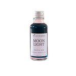 A small glass bottle of Wild Rising Moon Light Smoothing Serum with a silver cap and a white label, containing a dark blue liquid, set against a plain white background.
