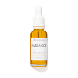 A 30ml glass dropper bottle of Wild Rising Radiance Retinolative Beauty Serum, filled with golden-yellow oil, featuring a white label and white dropper cap, set against a plain white background with a soft shadow.