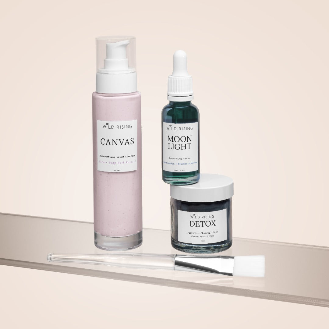 Three skincare products from Wild Rising on a beige surface with a light background