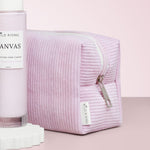 Pink textured pouch with 'Wild Rising' branding on a light pink background