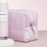 Pink textured pouch with 'Wild Rising' branding on a light pink background