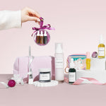 Collection of skincare and beauty products on a pink background