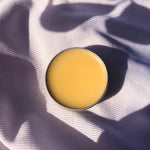 lip balm tin opened on shadow linen background