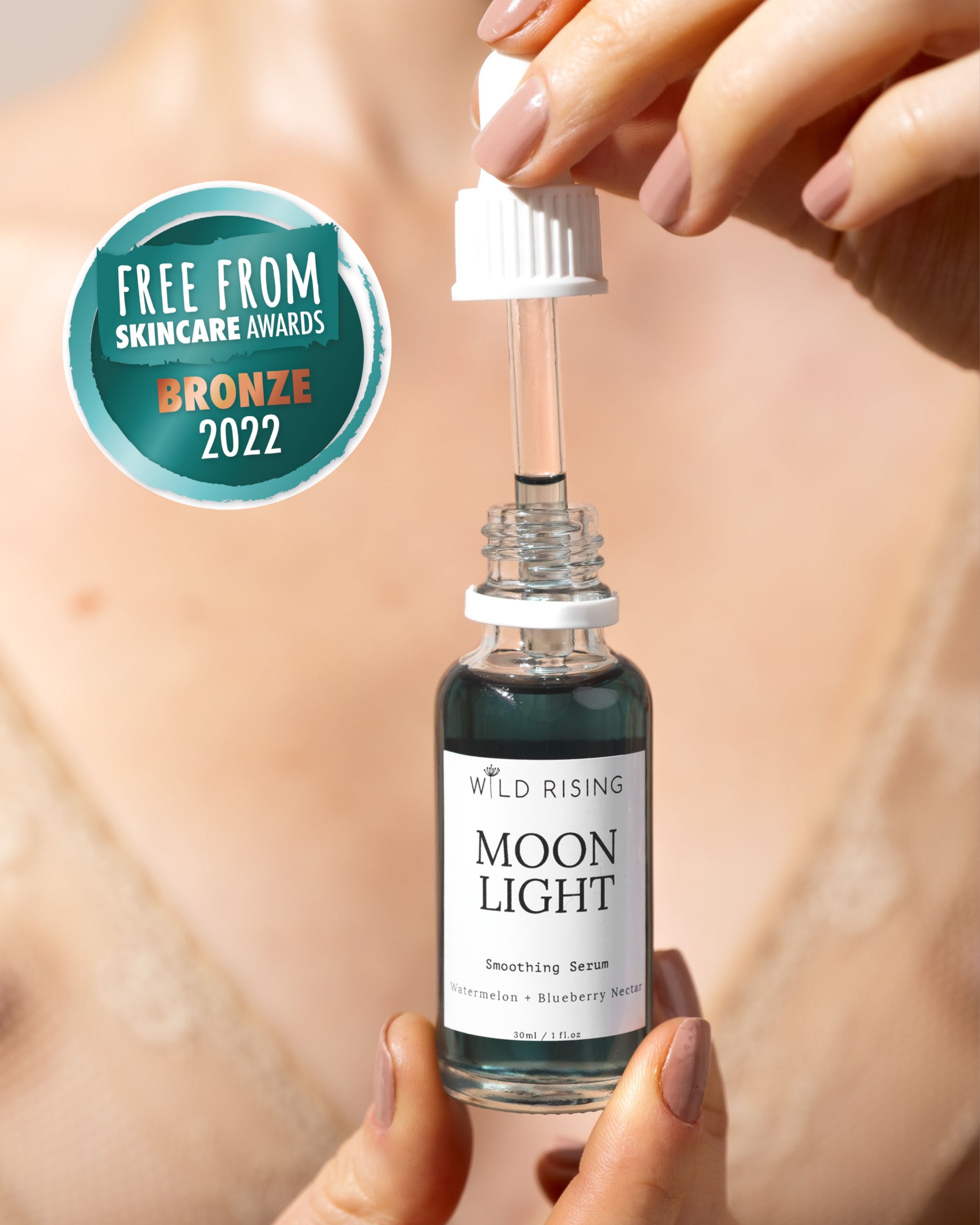 Hand holding a bottle of 'Moon Light' serum with a dropper, against a neutral background.