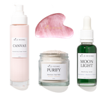 Four skincare products from Wild Rising arranged on a white background: a pale pink pump bottle labeled Canvas, a pink gua sha massage tool, a clear jar labeled Purify Botanical Face Mask, and a dark green dropper bottle labeled Moon Light Smoothing Serum