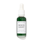 A bottle of Wild Rising Moon Light Smoothing Serum with a white dropper cap and a white label, containing a dark green liquid, set against a plain white background with a soft shadow.