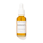 A 30ml glass dropper bottle of Wild Rising Radiance  Beauty Serum, filled with golden-yellow oil, featuring a white label and white dropper cap on a white background.