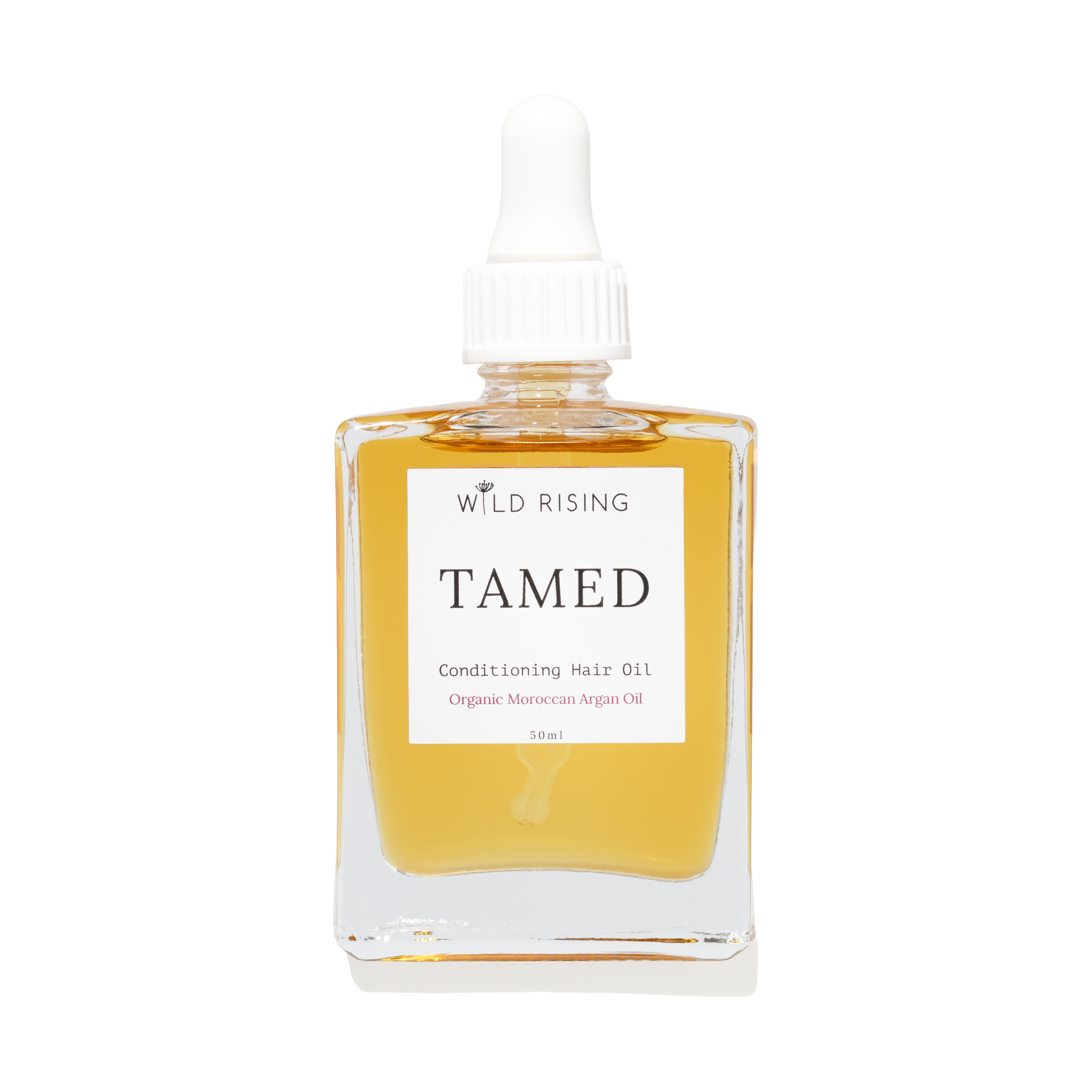 Wild Rising Tamed Conditioning Hair Oil in a clear square glass bottle with a white dropper cap, filled with golden-yellow oil, on a white background.