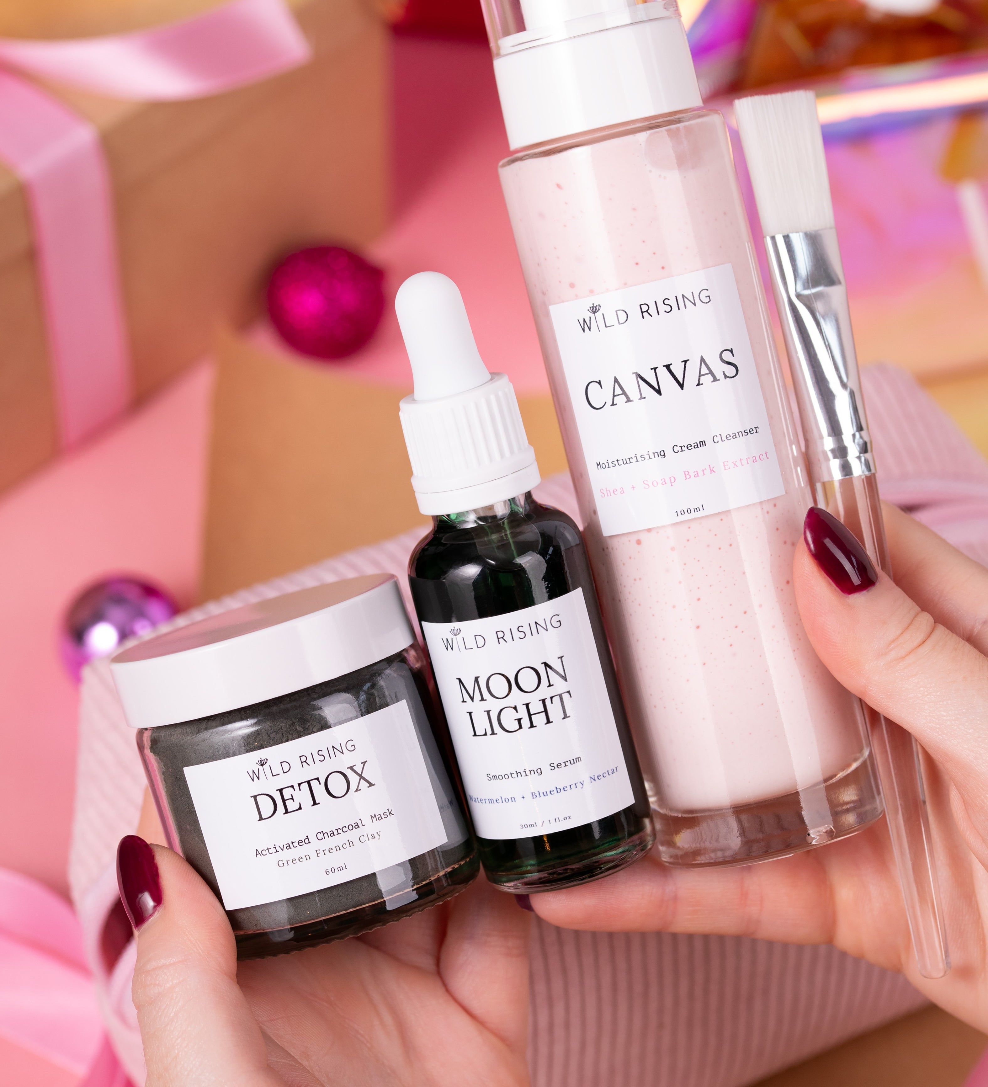 Hand holding skincare products with visible brand names against a colorful background
