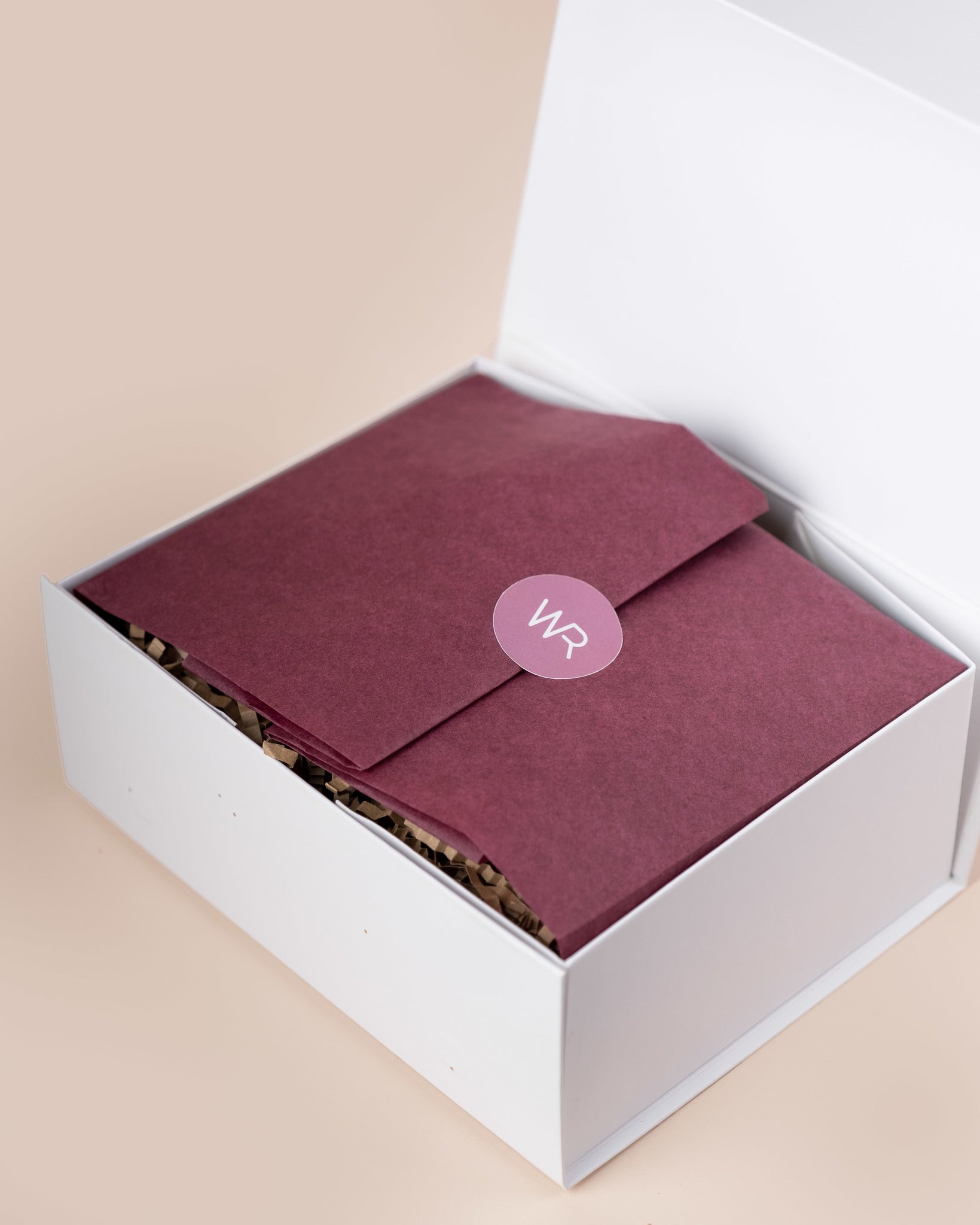 Mauve envelope with 'WR' logo in a white box on a beige background