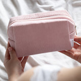 pink cosmetic bag being held