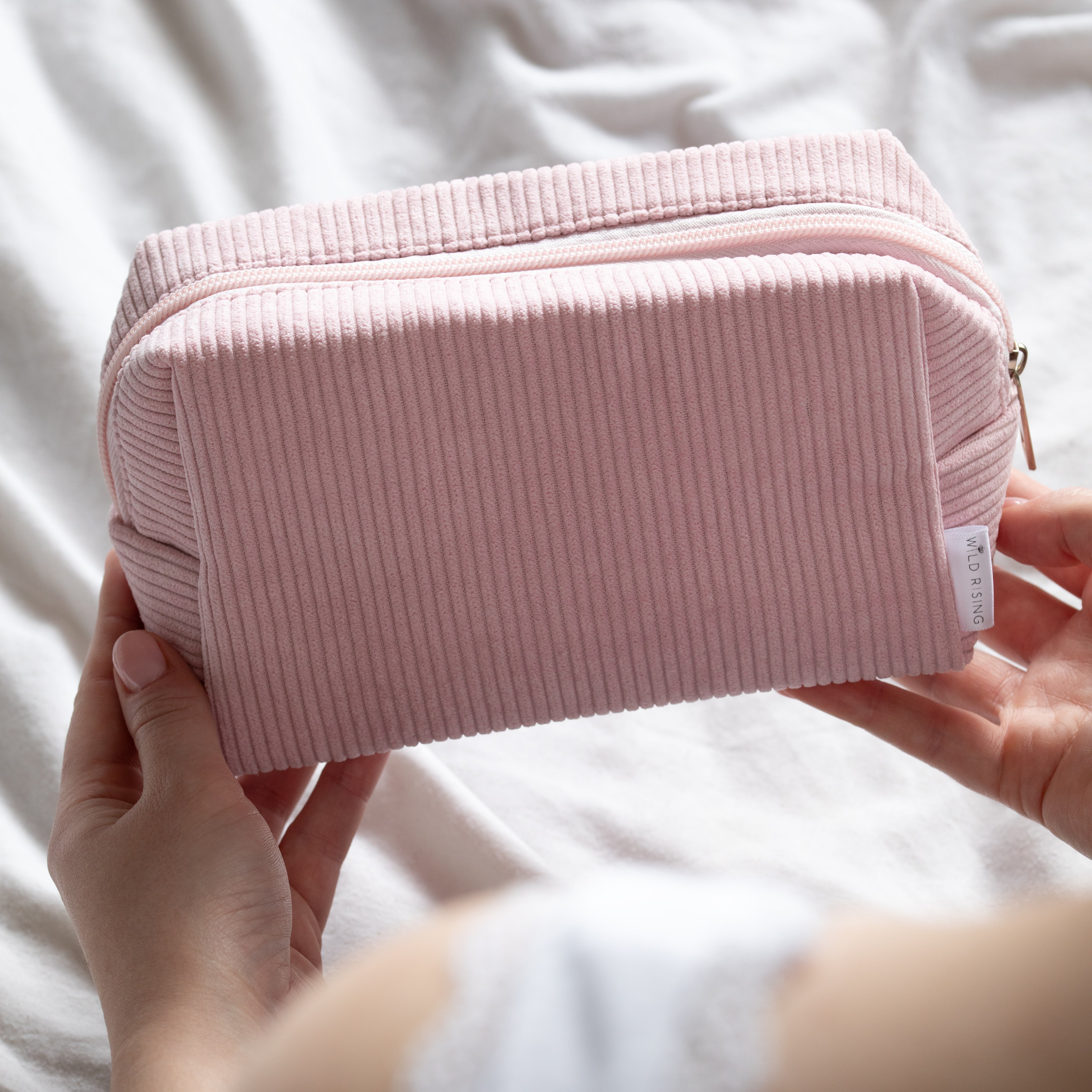pink cosmetic bag being held