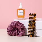 hair oil balance on gift box with comb and hair scrunchie