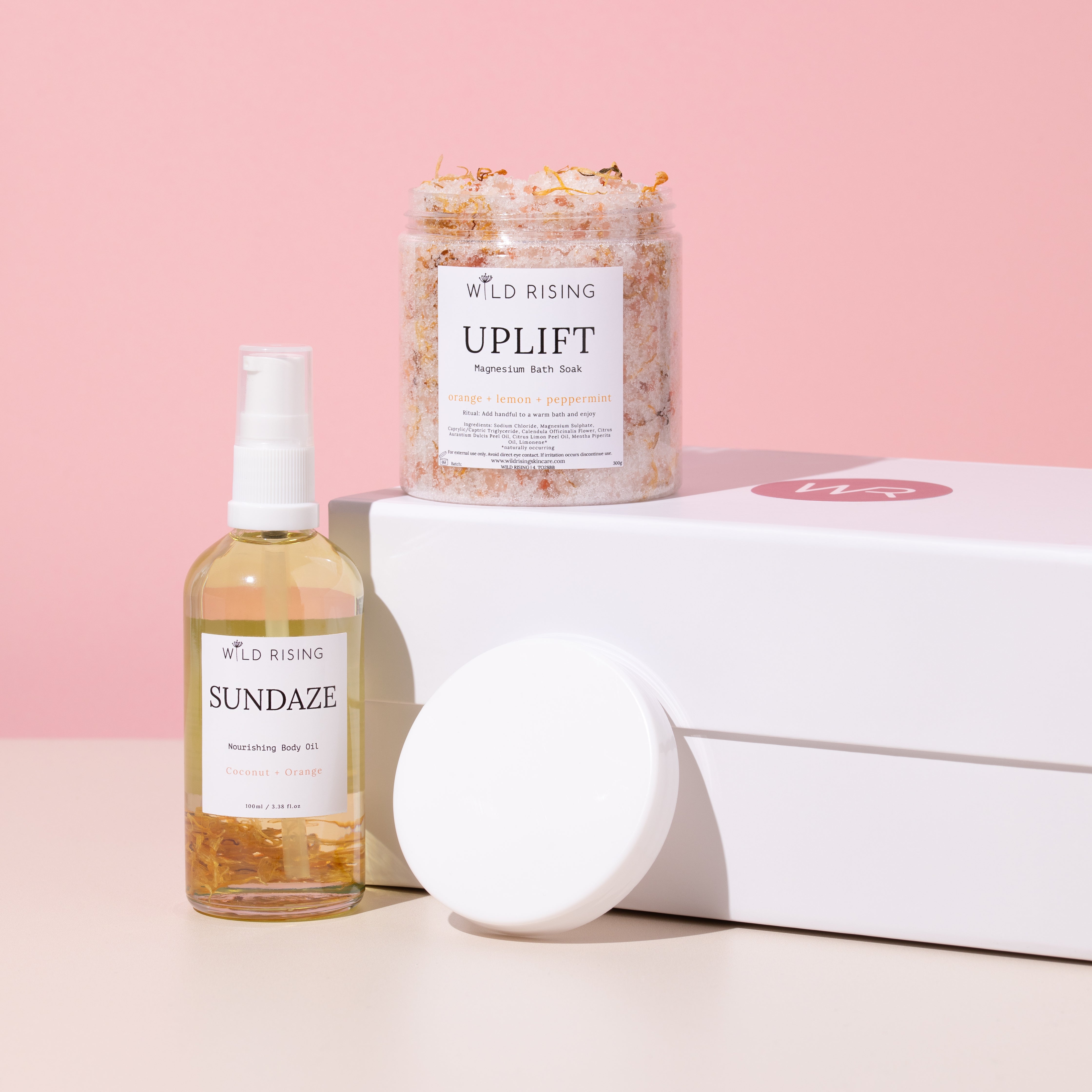 bath salts and body oil displayed in front of a gift box