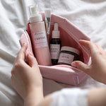 skincare products in a pink corded bag