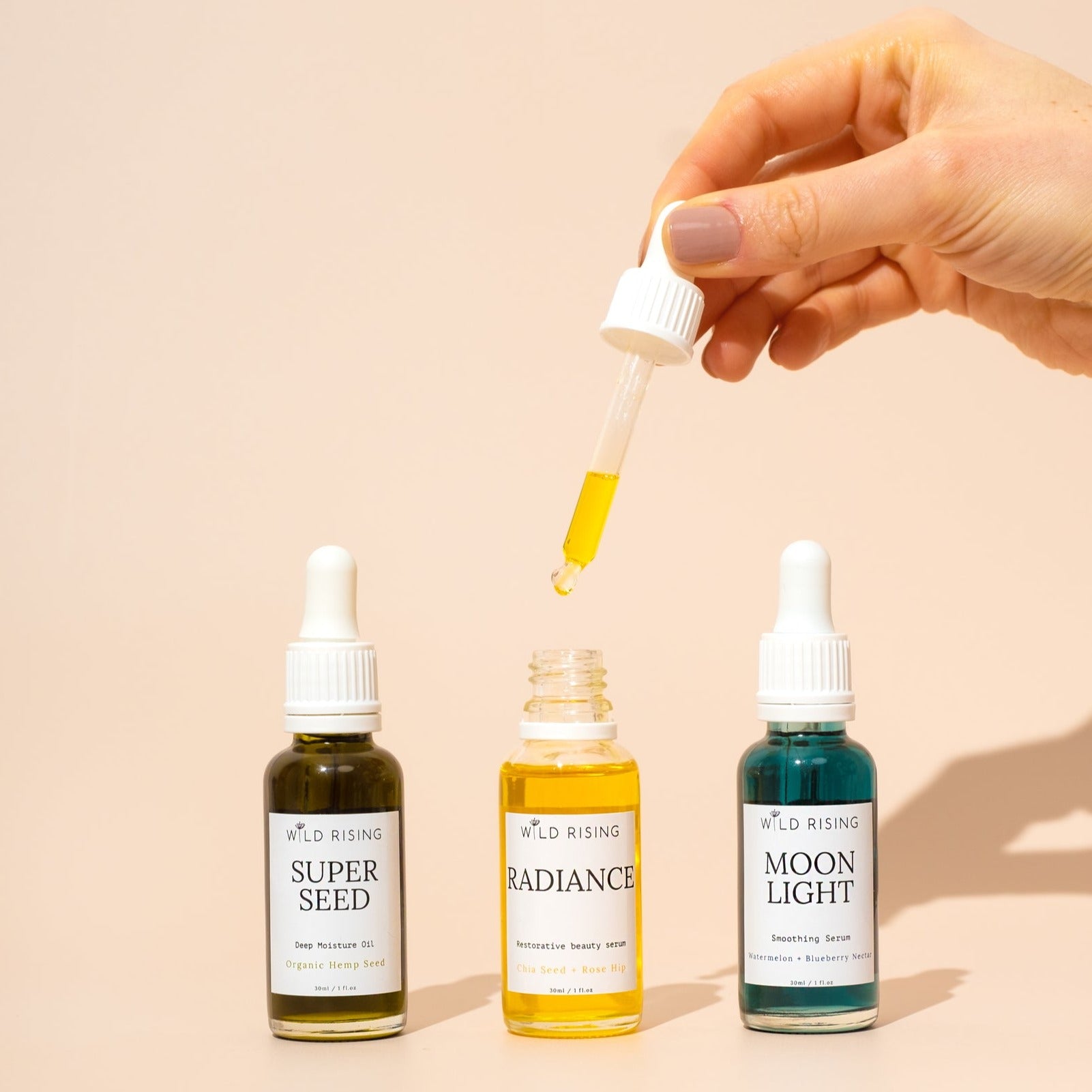three wild rising face oils. Radiance open with hand
