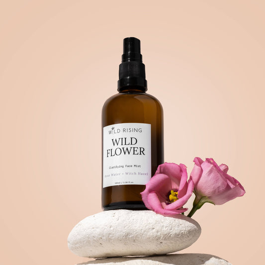 witch hazel with rose water toner balanced on three pebbles