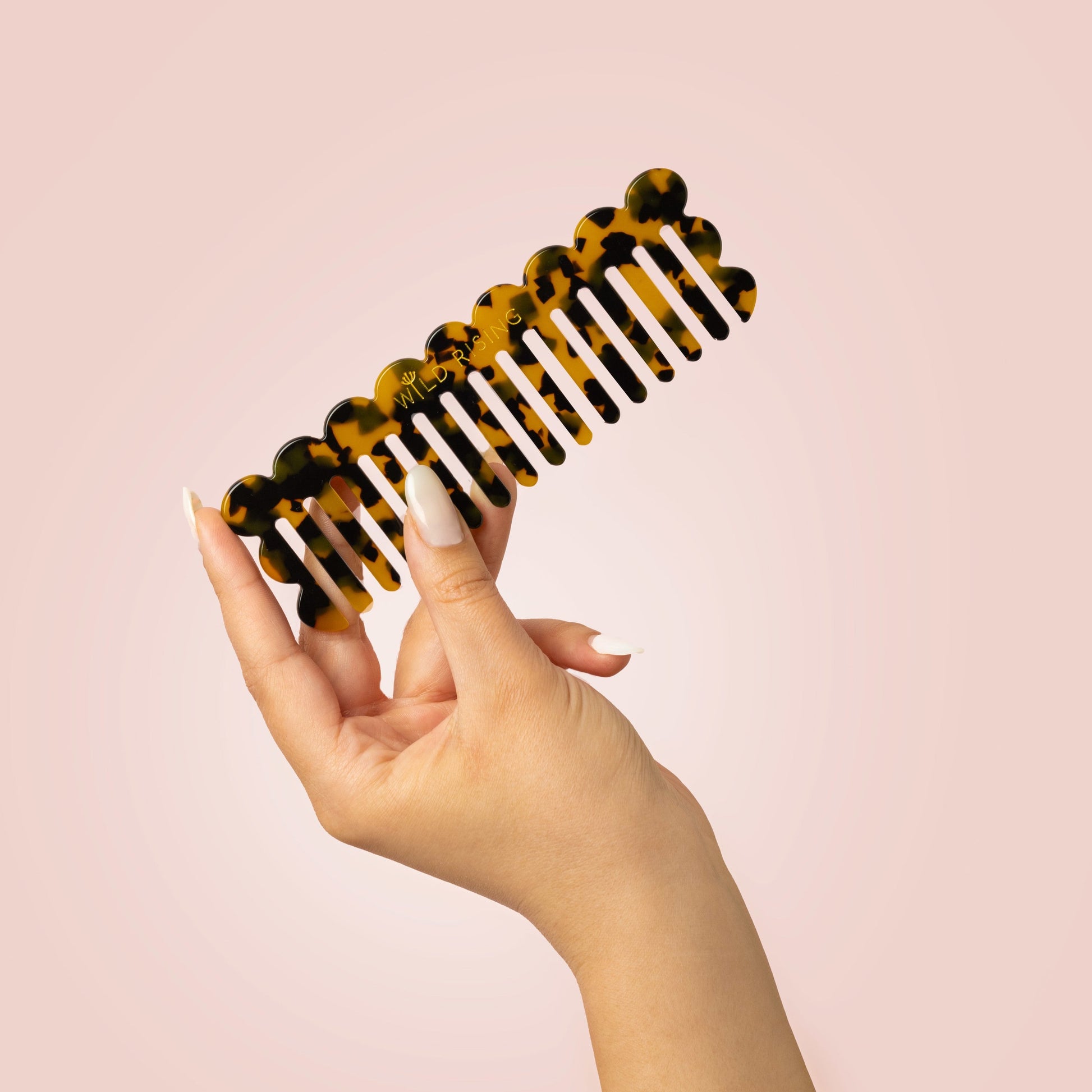 Model holding wide tooth comb in hand